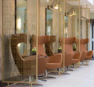 a row of chairs in a room with mirrors at DoubleTree by Hilton London Heathrow Airport in Hillingdon
