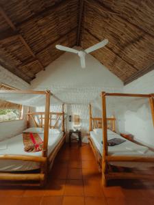 two beds in a room with a ceiling fan at Praba Hostel in Palomino