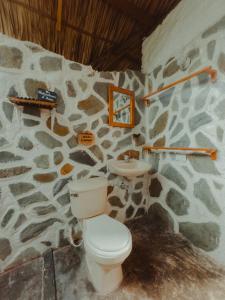Baño de piedra con aseo y lavamanos en Praba Hostel en Palomino