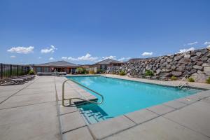 a swimming pool with a stone wall next to a building at Washington Home with Pool Access about 32 Mi to Zion NP! in Washington