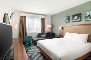 a hotel room with a bed and a chair at Hilton Garden Inn London Heathrow Airport in Hillingdon