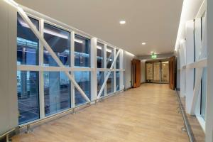 an empty hallway in a building with large windows at Hilton Garden Inn London Heathrow Terminal 2 and 3 in Hillingdon