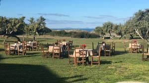 un grupo de mesas y sillas en un campo en Bellamarina, en Sorso