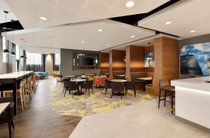 a restaurant with tables and chairs and a bar at Hampton By Hilton London Docklands in London