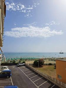 um parque de estacionamento com carros estacionados junto à praia em Monolocale 2\4 posti presso Residence la Spiaggia em Marotta