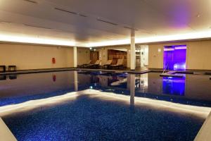 een zwembad in een hotel met paarse lichten bij Lincoln Plaza Hotel London, Curio Collection By Hilton in Londen