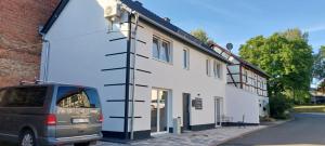 a van parked in front of a white building at Ferienhaus Winfried in Weberstedt