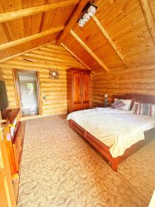 ein Schlafzimmer mit einem Bett in einer Holzhütte in der Unterkunft Sunset By The Farm in Piatra Neamţ