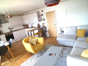 a living room with a couch and a kitchen at North Sea View Apartment in Scarborough