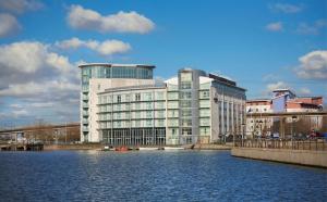 a large building next to a body of water at DoubleTree By Hilton London Excel in London