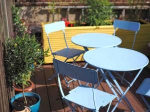 two tables and chairs on a patio with plants at Revival Retreat, with parking in Whitstable