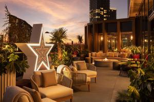 eine Terrasse mit Sofas und Stühlen auf einem Gebäude in der Unterkunft The Gantry London, Curio Collection By Hilton in London