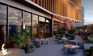 an outdoor patio with tables and chairs and plants at The Gantry London, Curio Collection By Hilton in London