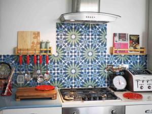 a kitchen with a stove and a patterned wall at Revival Retreat, with parking in Whitstable