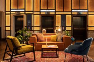 伦敦The Gantry London, Curio Collection By Hilton的客厅里有一张沙发和两把椅子