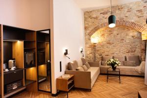 a living room with a couch and a stone wall at HOTEL TEATR in Kraków