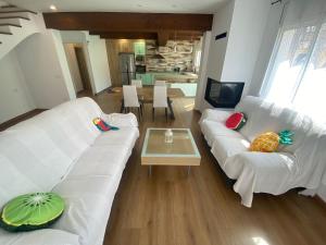 sala de estar con sofá blanco y mesa en Casa Libélula en Castelló d'Empúries