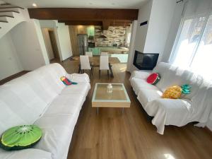 a living room with a white couch and a table at Casa Libélula in Castelló d'Empúries