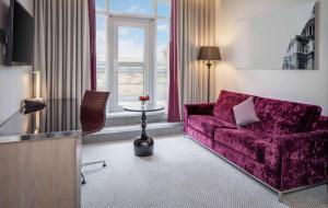 倫敦的住宿－希爾頓倫敦伊斯靈頓天使酒店，客厅配有紫色沙发和桌子