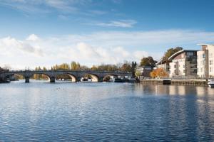 un ponte su un corpo idrico con edifici di DoubleTree by Hilton London Kingston Upon Thames a Kingston upon Thames