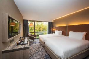 una camera d'albergo con un grande letto e una finestra di DoubleTree by Hilton London Kingston Upon Thames a Kingston upon Thames