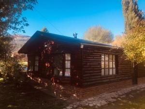 uma cabana de madeira com uma lareira dentro dela em Casanicca Habitaciones privadas en Casa Compartida em San Martín de los Andes