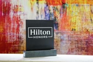 a black sign sitting on a table in front of a painting at DoubleTree by Hilton London Angel Kings Cross in London