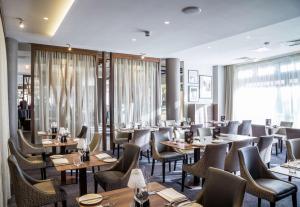 een restaurant met tafels en stoelen en een groot raam bij DoubleTree by Hilton London Angel Kings Cross in Londen