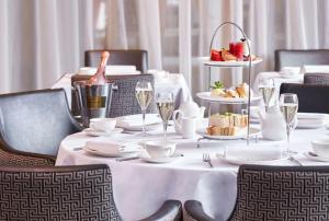 a table with white plates and glasses of wine at DoubleTree by Hilton London Angel Kings Cross in London