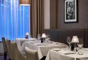 a dining room with tables and chairs with white tablecloths at DoubleTree by Hilton London Angel Kings Cross in London