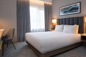 a hotel room with a large bed and a window at DoubleTree by Hilton London Angel Kings Cross in London