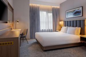 a hotel room with a large white bed and a desk at DoubleTree by Hilton London Angel Kings Cross in London