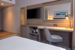 a hotel room with a bed and a desk with a television at DoubleTree by Hilton London Angel Kings Cross in London