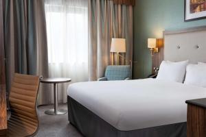 a hotel room with a large bed and a chair at DoubleTree by Hilton London Angel Kings Cross in London