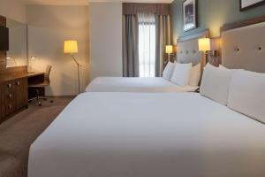 a hotel room with two beds and a desk at DoubleTree by Hilton London Angel Kings Cross in London