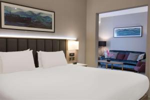 a bedroom with a large bed and a living room at DoubleTree by Hilton London Angel Kings Cross in London