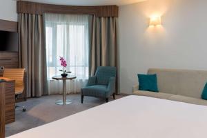 a hotel room with a bed and a couch and a window at DoubleTree by Hilton London Angel Kings Cross in London