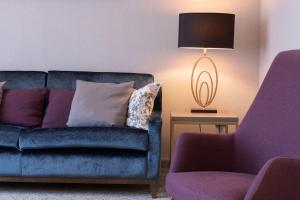 a living room with a blue couch and a lamp at DoubleTree by Hilton London Angel Kings Cross in London