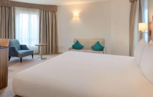 a hotel room with a large bed and a chair at DoubleTree by Hilton London Angel Kings Cross in London