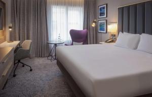 a hotel room with a large white bed and a desk at DoubleTree by Hilton London Angel Kings Cross in London