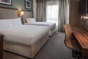 a hotel room with two beds and a desk at DoubleTree by Hilton London Angel Kings Cross in London