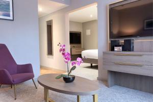 a living room with a tv and a table with a flower at DoubleTree by Hilton London Angel Kings Cross in London