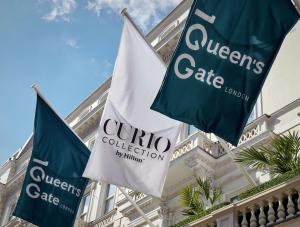 dos banderas azules y blancas delante de un edificio en 100 Queen’s Gate Hotel London, Curio Collection by Hilton, en Londres