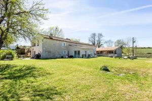 an old house with a large yard in front of it at Le Cœur du Breuil in Segonzac