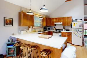 a kitchen with a white counter and wooden cabinets at The Three Cornered Pond Retreat in Augusta