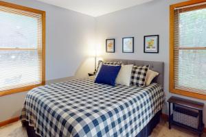 a bedroom with a bed with a blue and white checkered blanket at The Three Cornered Pond Retreat in Augusta