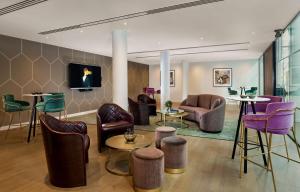 伦敦The Westminster London, Curio Collection by Hilton的客厅配有桌椅,大堂