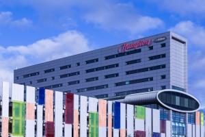 a building with a sign on the side of it at Hampton by Hilton Liverpool John Lennon Airport in Speke