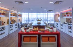 a kitchen with a red table with food on it at Hampton by Hilton Liverpool John Lennon Airport in Speke