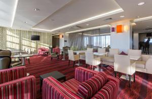 um átrio do hotel com sofás, mesas e cadeiras em Hampton by Hilton Liverpool John Lennon Airport em Speke
